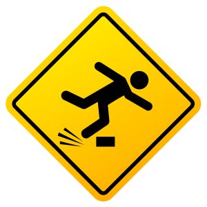 a yellow sign warning of a trip and fall at work hazard