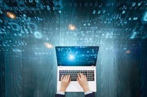Hands working on laptop against a background of three-dimensional computer code.