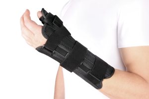 A wrist brace on a man's hand on an isolated white background