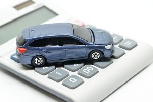 Grey calculator with a blue car on top depicting a road accident compensation calculator. 