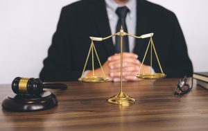 A fatal accident at work solicitor sat on a desk with judgement scales and a gavel in front of them.