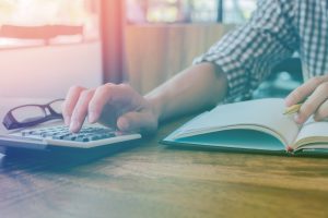 A solicitor using a calculator to help value personal injury compensation a claimant might receive.