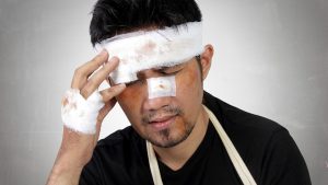 A man with bandages on his head due to head and facial injuries that may leave permanent scarring.