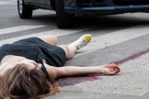 Person laying badly injured in the road after a pedestrian accident