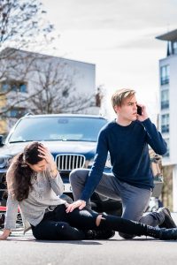 Pedestrian in the road after a collision while the driver calls for emergency services