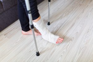 Someone with their leg in plaster using crutches