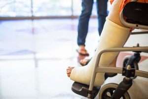 Person in wheelchair with cast on leg.