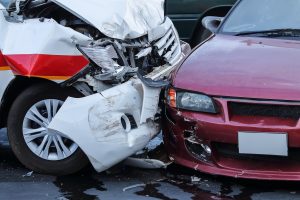 A pair of cars display damage after a collision.
