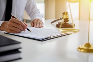 A solicitor writing on a document about severe eye injuries and the total blindness of one of his claimants.