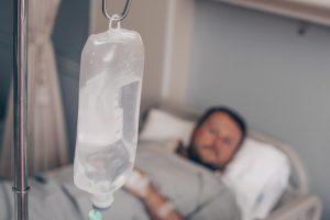A patient with an IV drip thinking about sepsis misdiagnosis claims.