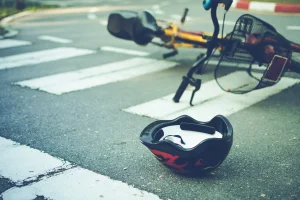 A helmet and bicycle lies on a road after an accident