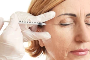 A woman has a facial injection next to her eye.