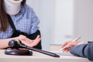 A claimant with serious injuries discusses a motorbike accident compensation claim with a lawyer while sat at a desk