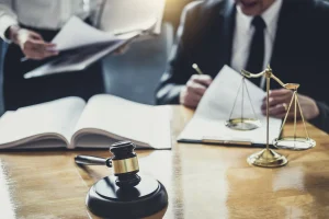 Two lawyers process paper work at a desk for the motorcycle accident compensation claims they are handling