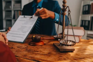 A solicitor pointing at a document on how to claim compensation for a brain or head injury claim for a client to look over.