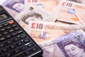 A close up of £10 and £20 notes and a calculator.