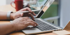 A close up photo of a person researching on a laptop.