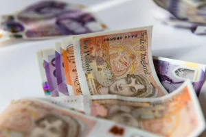 Fall from height compensation consisting of tenners and £20 notes on a table. 