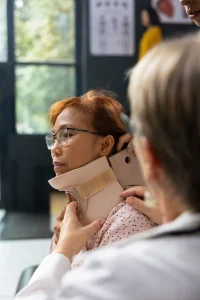 A woman undergoing neck injury treatment with a collar. 