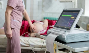 A pregnant woman is monitored by a midwife.