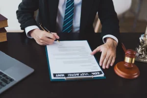 Solicitor at desk signing a contract for a No Win No Fee arrangement to help a client claim for GBH compensation