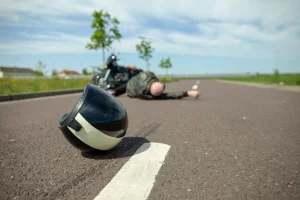 A bike helmet lies on the road after a rider suffers a serious motorcycle accident injury.